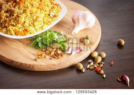 pilaf with garlic, raisins, olives, cardamom, parsley on a wooden cutting board