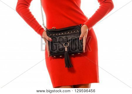 Fashionable woman with a black bag in her hands and red evening dress