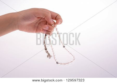 Hand holding a tespih on a white background