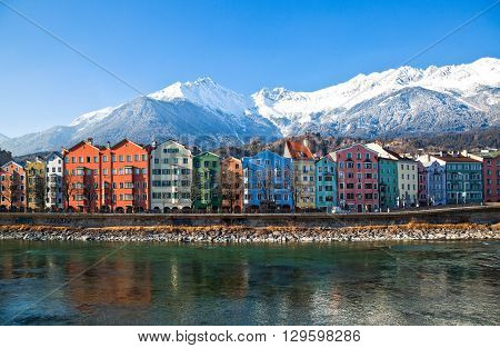 Innsbruck Austria - February 8 2010: The Mariahilf strasse colored houses on the Inn river with the snowy mountains in the background