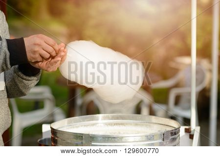 Men is preparing candy floss in the park. Children Day