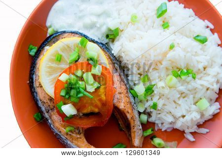 Steak of Keta cooked with tomato, rice, onion and lemon . Delicious dish of keta