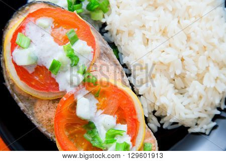 Steak of Keta cooked with tomato, rice, onion and lemon . Delicious dish of keta