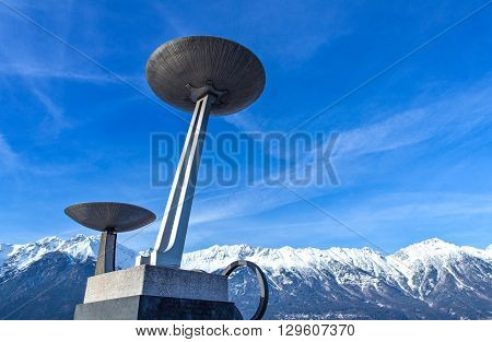 Innsbruck Austria - February 8 2010: The Olympic braziers of the Bergisel skijamping stadium with the snowy mountains in the background