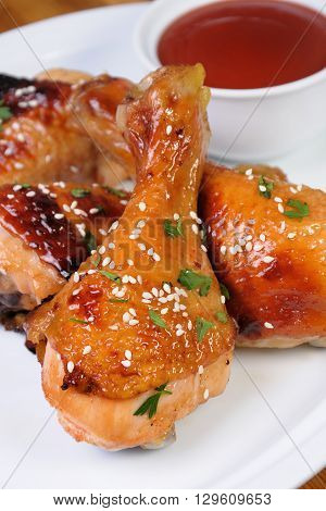 Fried chicken leg with sesame seeds in a plate and sauce