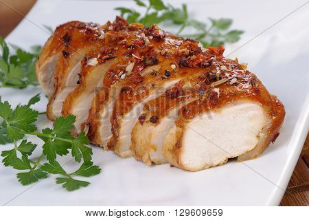 baked chicken breast sliced on a plate close-up