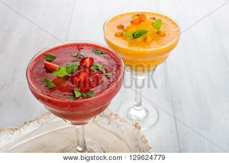 Two glass of strawberry and buckthorn smoothie on a whight wooden background