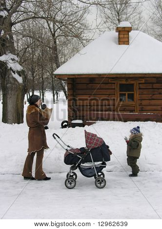Mutter mit Kindern. Schnee. Haus.