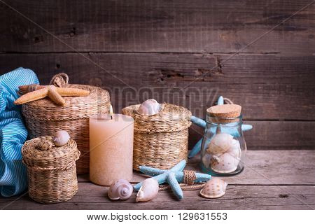 Сandle and marine items on aged wooden background. Sea objects on wooden planks. Selective focus.