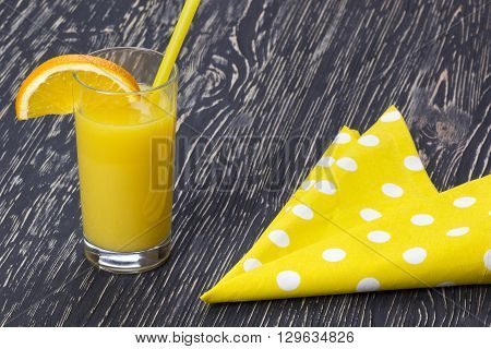 Orange juice in the glass on black wooden table