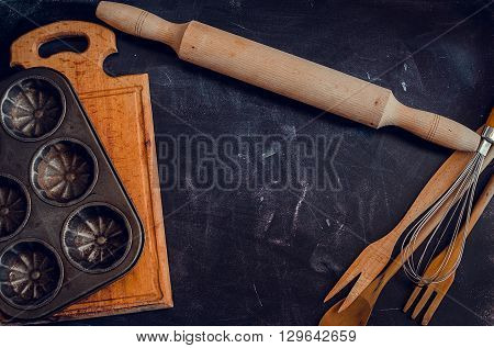Rural kitchen utensils on blackboard from above - rustic background with free text space. Baking concept. Baking background. Baking preparation. Different stuff. Top view. Copy space.