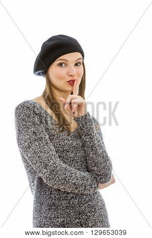 Portrait of a young woman with a silence gesture isolated against a white background.