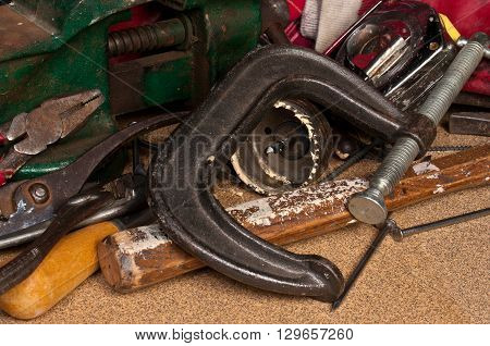 Still life photo of various hand tools with a sandpaper base