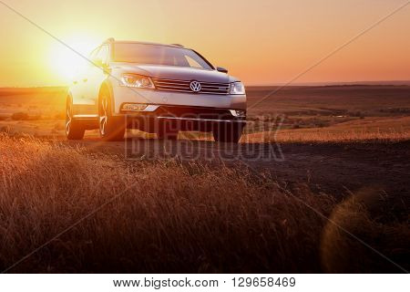 Saratov, Russia - June 02, 2014: Grey car Volkswagen Passat stay on dirt road at sunset