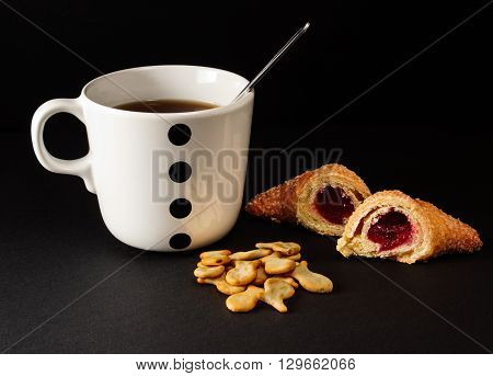 A cup of tea and cookies on a black background