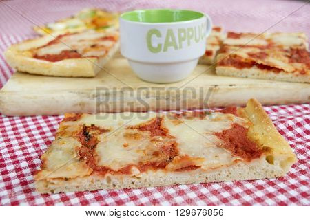handcraft margherita pizza with near a cup of cappuccino