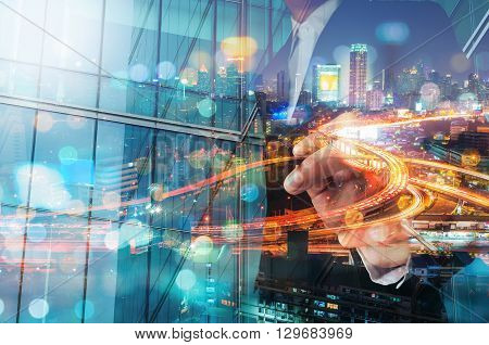 Double Exposure Of Businessman Draw Something With City Traffic Scene At Night