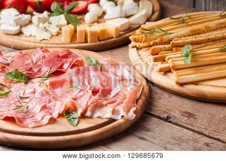 Italian appetizer - various types of ham, cheese and grissini