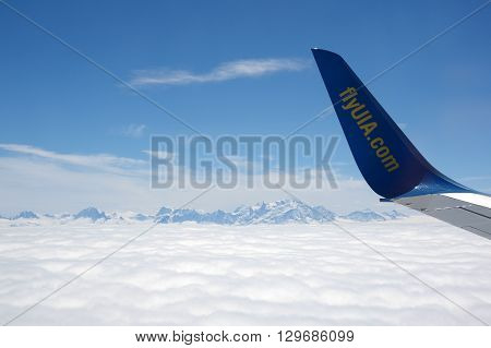 GENEVE AIRPORT SWITZERLAND ALPES - APRIL 28 2015: An Aircraft operated by UIA (Ukraine International Airlines) flying between Alpes mountains before landing in Geneve airport