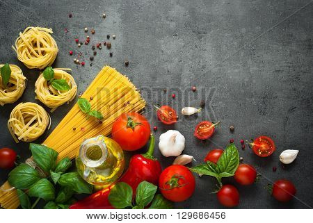 Ingredients for cooking Italian pasta - spaghetti tomatoes basil and garlic. Top view with space for taxt.