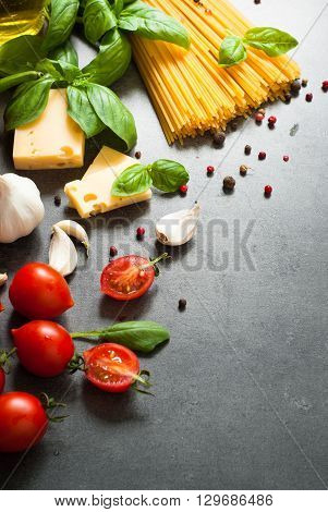 Ingredients for cooking Italian pasta - spaghetti tomatoes basil and garlic. Top view with space for taxt.