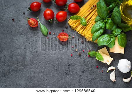 Ingredients for cooking Italian pasta - spaghetti tomatoes basil and garlic. Top view with space for taxt.