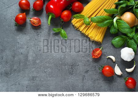 Ingredients for cooking Italian pasta - spaghetti tomatoes basil and garlic. Top view with space for taxt.
