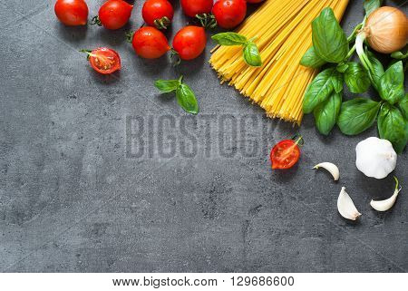 Ingredients for cooking Italian pasta - spaghetti tomatoes basil and garlic. Top view with space for taxt.