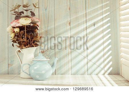 Morning still life on shabby chic table and light from the blinds