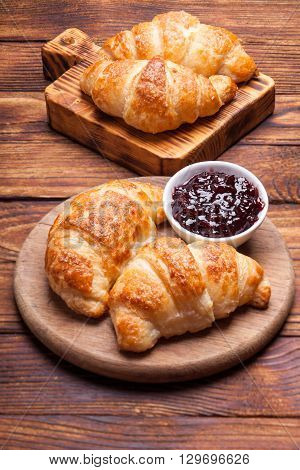 Two  delicious croissants on a wooden cutting board