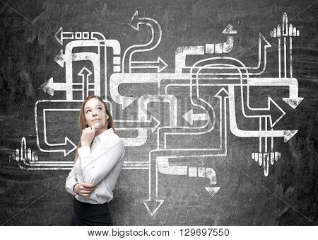 Different direction concept with thoughtful businesswoman next to chalkboard with arrows sketch
