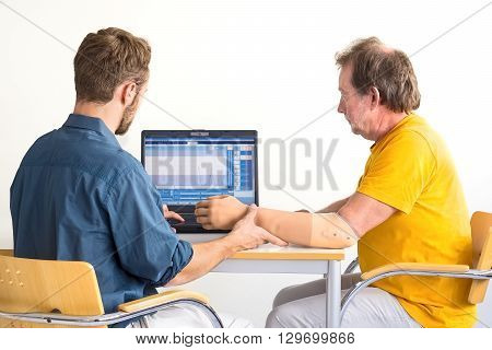 Medical Professional And Amputee Work Together. Computer-based Arm-prosthesis Adjustment.