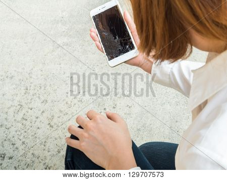Woman Picking Broken Smart Phone from the Floor