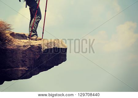 successful woman hiker enjoy the view at mountain cliff