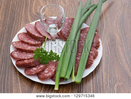 sausage on a white plate and a glass
