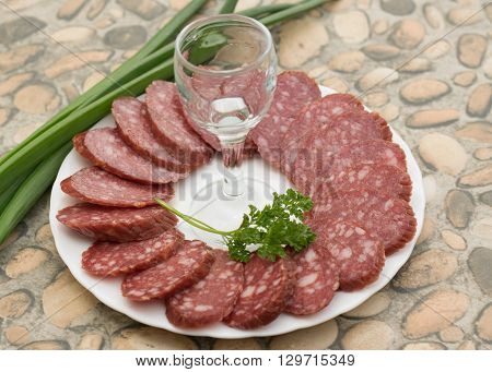 sausage on a white plate and a glass