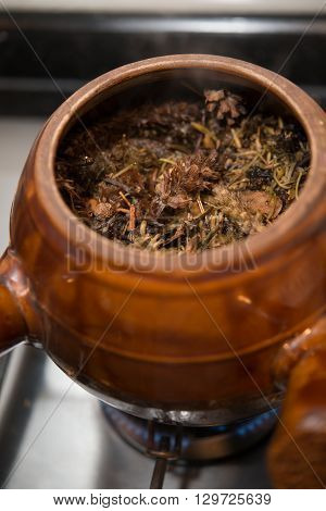 decocting medicinal herbs with enamel pot on gas burner