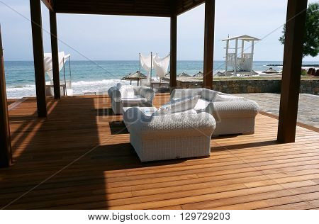 HERAKLION, CRETE, GREECE - MAY 13, 2014: The modern terrace with arm-chairs on the beach of Mediterranean coast of Crete, May 13, 2014, Greece.