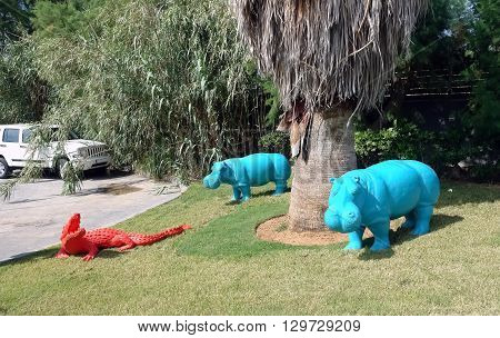 HERAKLION CRETE GREECE - MAY 13 2014: The two blue decorative hippopotamus and red crocodile on the terrain of luxury class hotel on the Mediterranean coast of Crete, May 13, 2014, Greece.