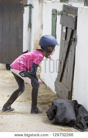 pretty young teenage girl preparing looking at horse poney