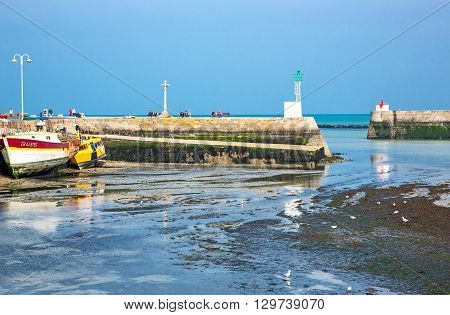 Barfleur France - May 21 2012: Normandy view of the harbor and boats at low tide near the village.