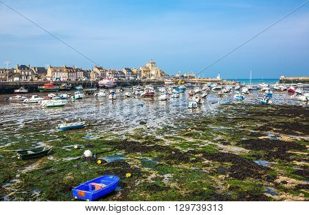Barfleur France - May 21 2012: Normandy view of the harbor and boats at low tide near the village.