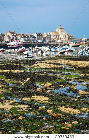 Barfleur France - May 21 2012: Normandy view of the harbor and boats at low tide near the village.