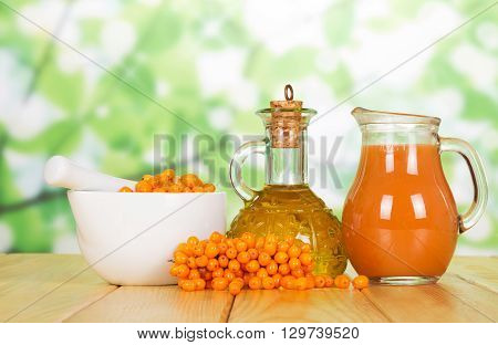 Seabuckthorn juice and oil from her abstract green background