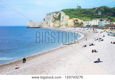 Etretat France - May 19 2012: Normandy local people relaxing on the beach near the cliffs .