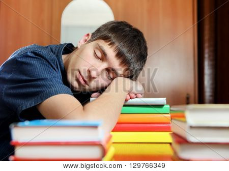 Tired Young Man sleep on the Books at the Home