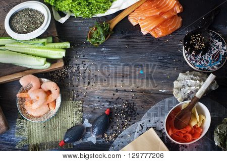 Food background, a wooden table top, sushi rolls cucumbers Chuka ginger, shrimp salmon seaweed