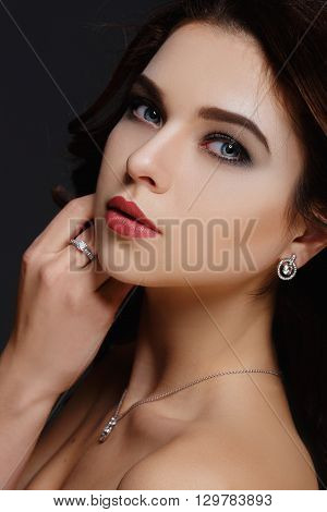 Sexy Beauty Girl with Red Lips. Make up. Luxury Woman with Long Curly Hair. Fashion Brunette Portrait isolated on a grey background. Gorgeous Woman Face.
