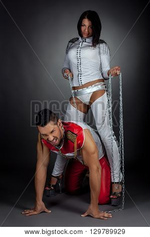 Couple of dance show. Imperious woman and guy in chains
