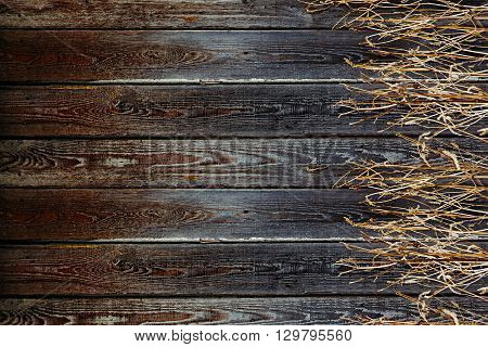 Old wooden fence. Vintage boards and dry grass. Wooden background. Wooden texture.